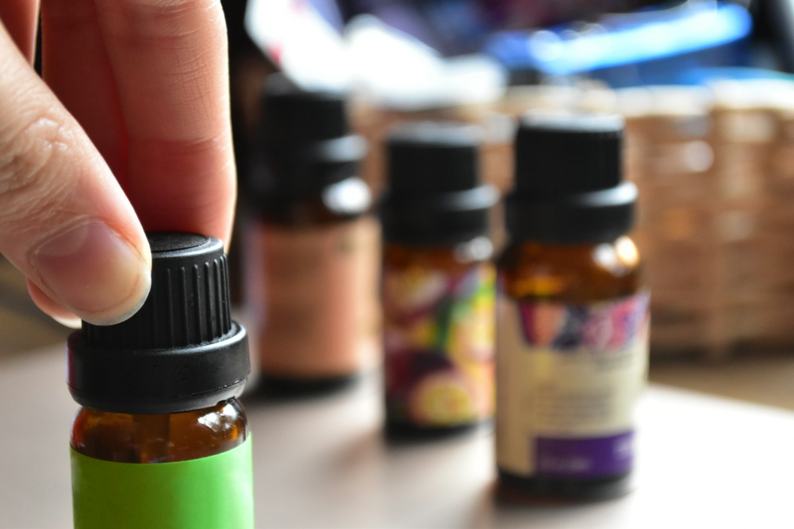 main tenant un flacon d'huile essentielle, geste artisanal caractéristique de la parfumerie indépendante