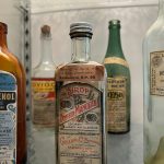 anciens flacons d'apothicaire et étiquettes, symbole de la parfumerie artisanale et du savoir-faire du geste