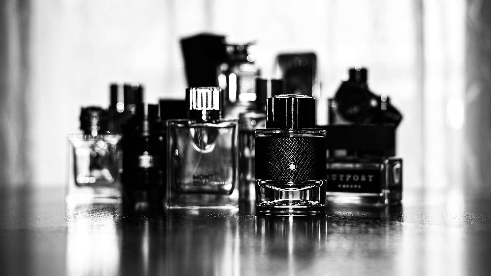 Plusieurs flacons de parfum côte à côte — tester plusieurs extraits avant d'acheter — Noble Essence