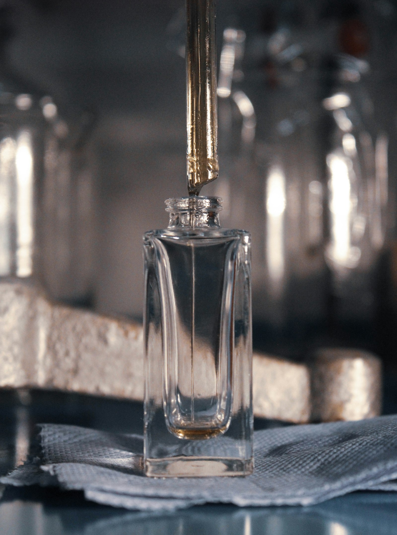 flacon de parfum en cours de remplissage à la pipette, dernière étape avant la mise en flacon