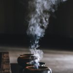 fumée de trois brûle-encens s'élevant en rangée, usage rituel de l'encens à travers les civilisations