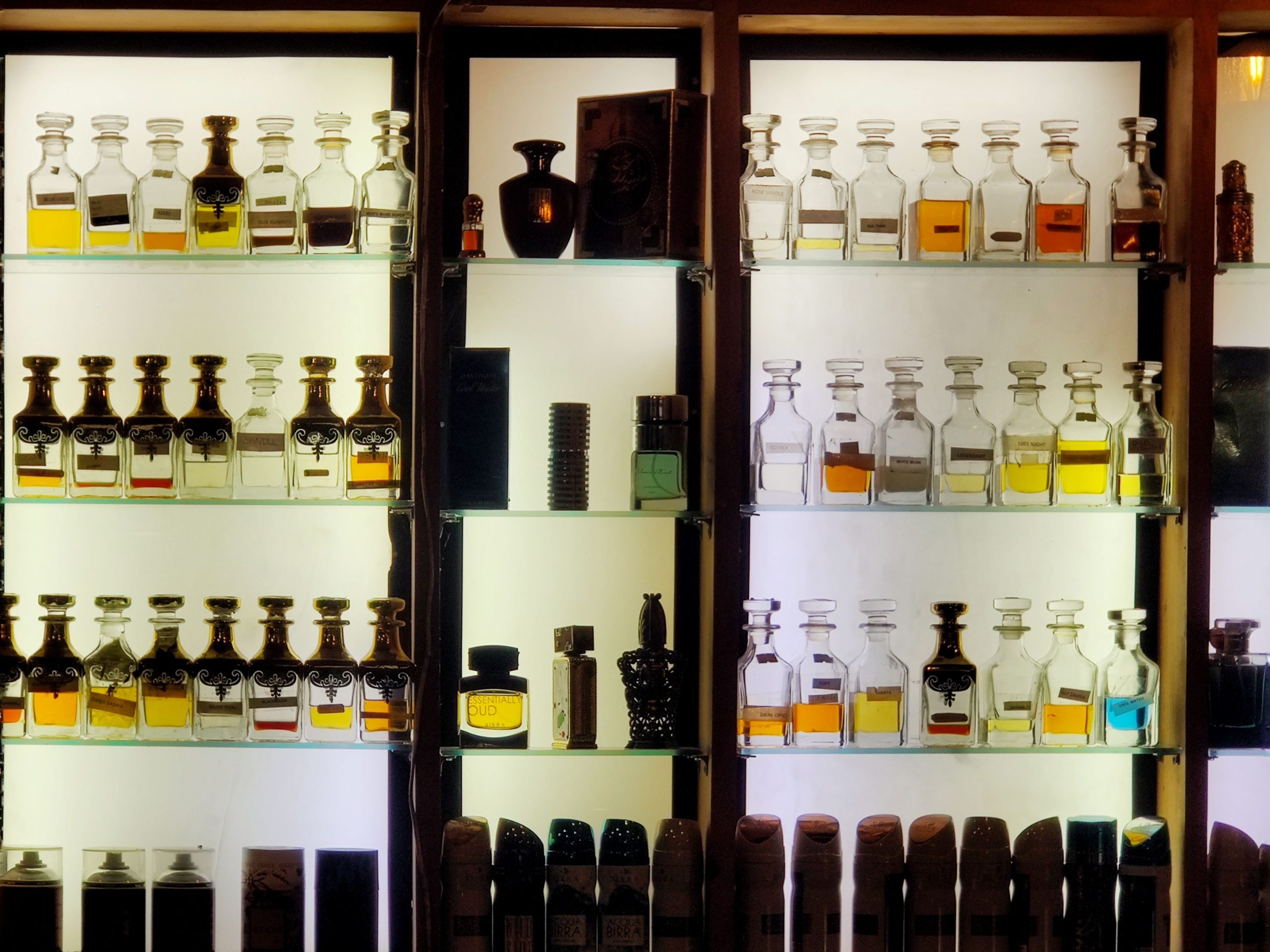 Flacons de parfum alignés sur une étagère éclairée — conservation du parfum Noble Essence