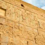 hiéroglyphes égyptiens anciens gravés dans la pierre, témoins des premiers usages du parfum