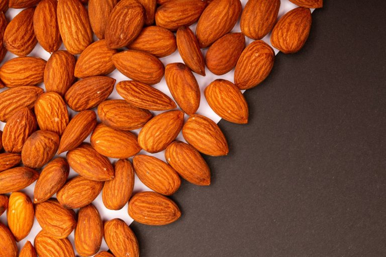 amandes brutes sur fond sombre, fruit à coque à l'origine de la note amande en parfumerie