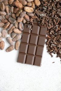 chocolat brut à côté de noisettes, matières évoquées dans les parfums gourmands