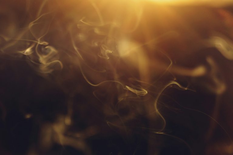Volutes de fumée dorées et transparentes — molécule Iso E Super en parfumerie — Noble Essence