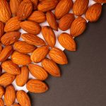 Amandes brunes sur fond sombre — matière de la pâte d'amande en parfumerie — Noble Essence