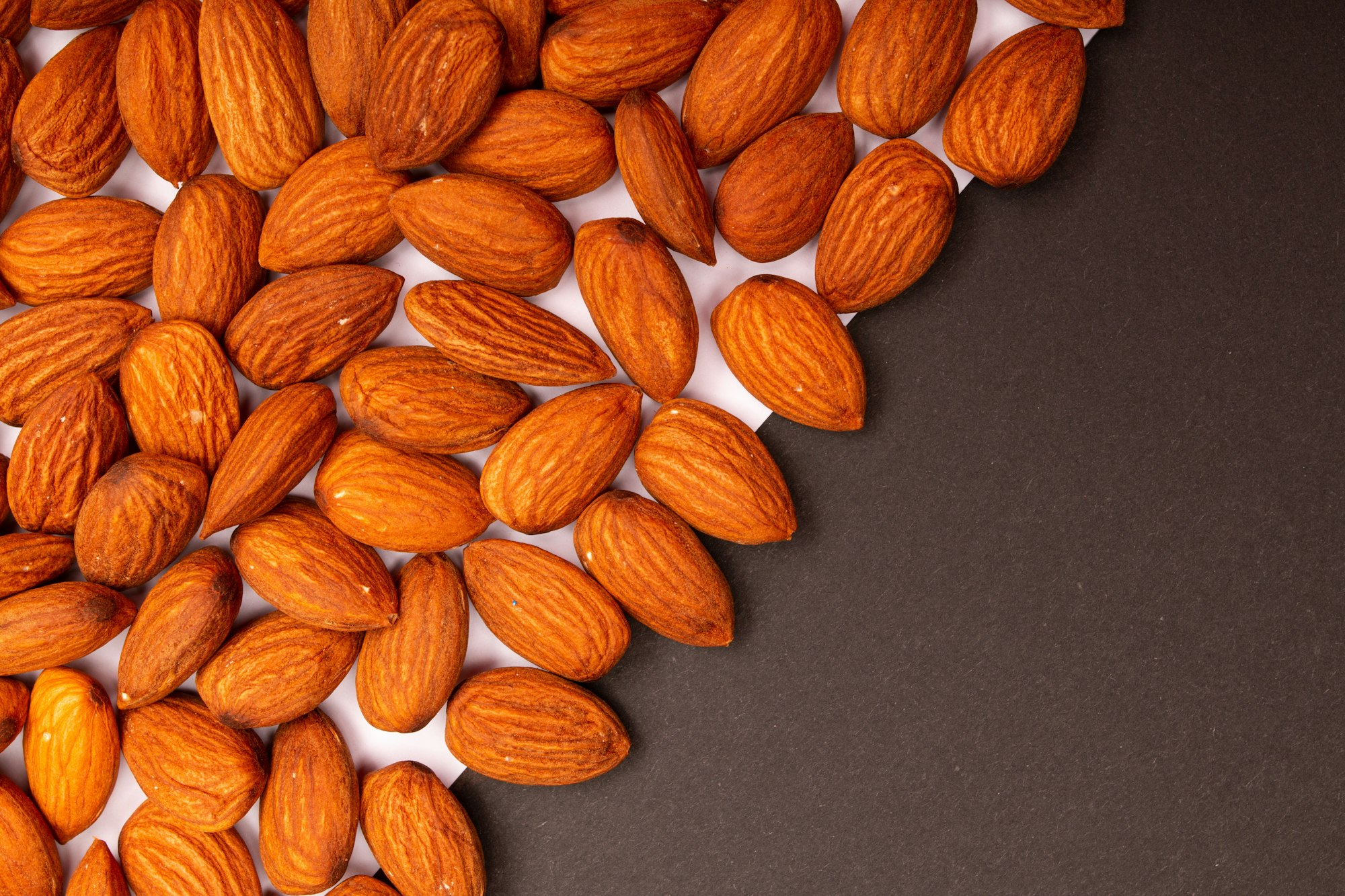 Amandes brunes sur fond sombre — matière de la pâte d'amande en parfumerie — Noble Essence