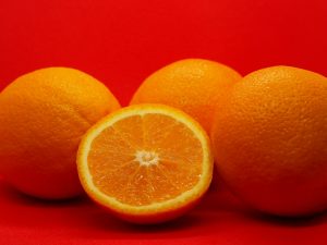 Orange coupée à côté de trois oranges entières — orange douce et amère en parfumerie — Noble Essence