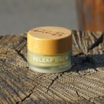 Petit contenant doré et blanc évoquant un parfum solide en baume — Noble Essence