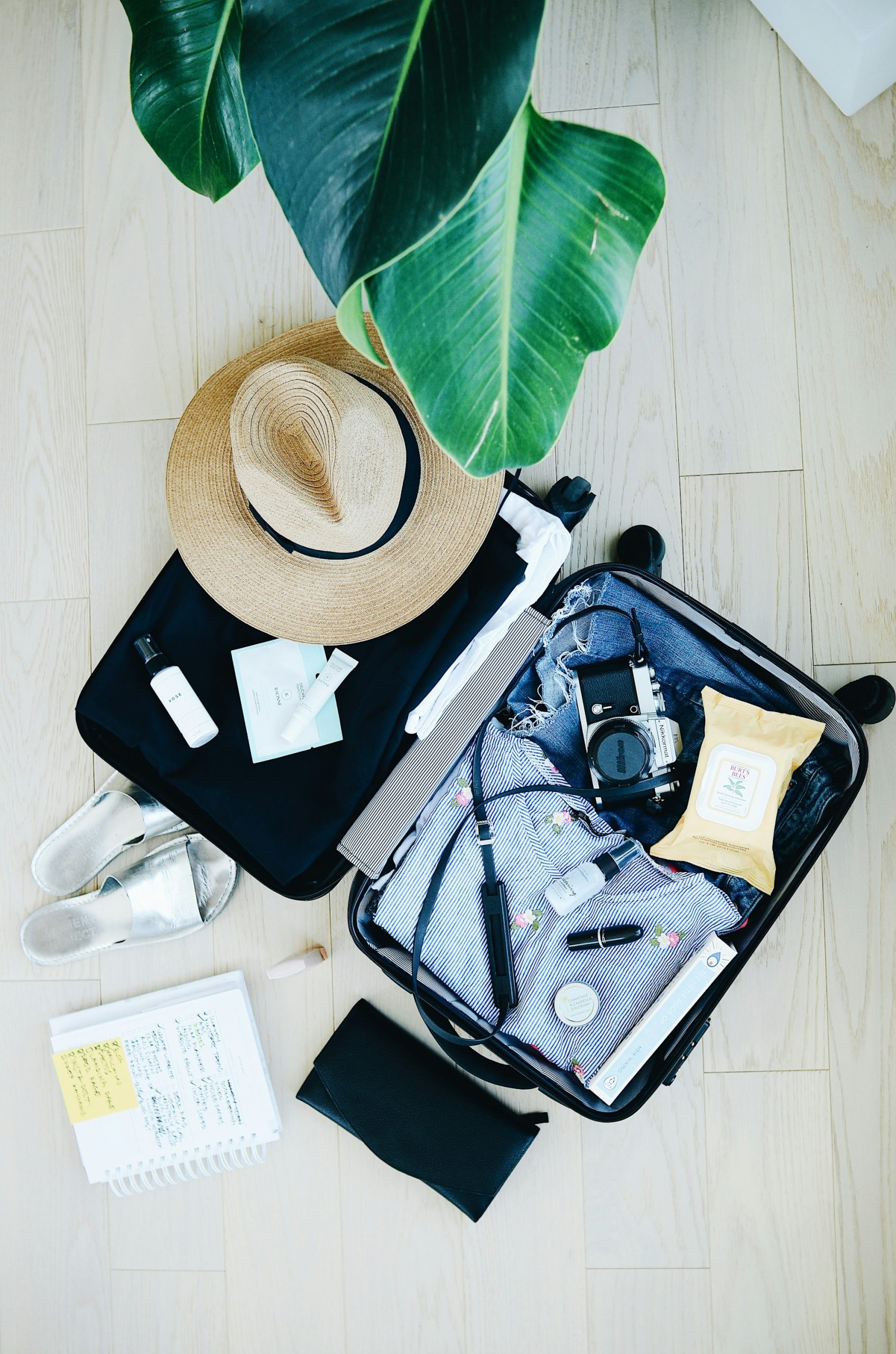 Valise ouverte avec effets de voyage — emporter son parfum en avion — Noble Essence